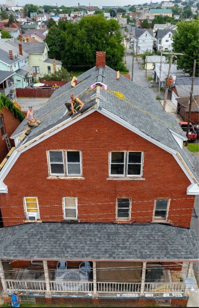 John standing at the peak of a roof